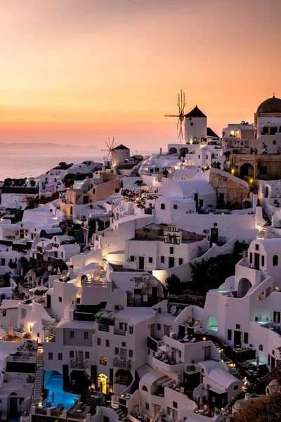 Sonnenuntergang auf der Insel Santorin Griechenland, schönes weiß getünchtes Dorf Oia mit Kirche und Windmühle bei Sonnenuntergang — Stockfoto