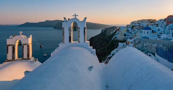 Solnedgång på ön Santorini Grekland, vackra vitkalkade byn Oia med kyrka och väderkvarn under solnedgången — Stockfoto