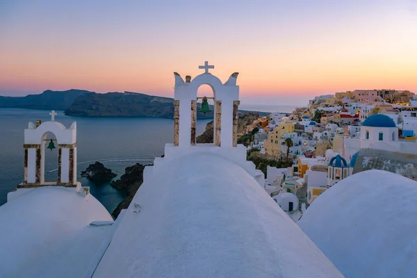 日落时分，在希腊圣托里尼岛上，美丽的粉刷过的村庄Oia，日落时分，那里有教堂和风车 — 图库照片