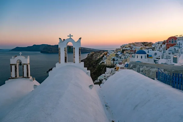 Sonnenuntergang auf der Insel Santorin Griechenland, schönes weiß getünchtes Dorf Oia mit Kirche und Windmühle bei Sonnenuntergang — Stockfoto