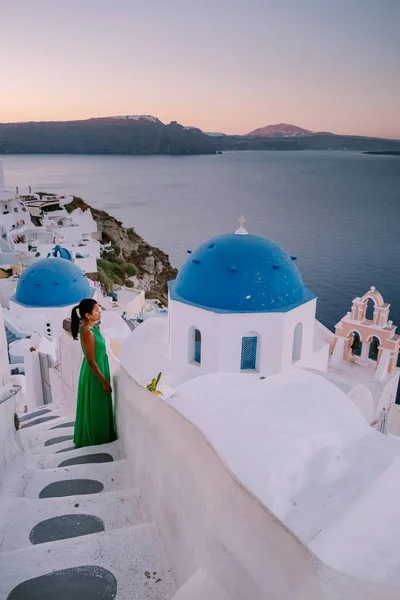 Puesta de sol en la isla de Santorini Grecia, hermoso pueblo encalado Oia con iglesia y molino de viento durante la puesta de sol Mujer en vacaciones de lujo Grecia — Foto de Stock