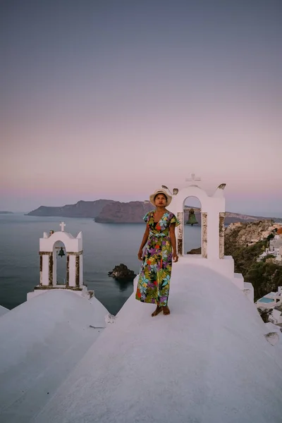 Puesta de sol en la isla de Santorini Grecia, hermoso pueblo encalado Oia con iglesia y molino de viento durante la puesta de sol Mujer en vacaciones de lujo Grecia — Foto de Stock
