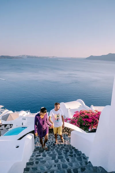 Santorini Griechenland, junges Paar im Luxusurlaub auf der Insel Santorini beim Sonnenaufgang an der blauen Kuppelkirche und dem weiß getünchten Dorf Oia Santorini Griechenland, Männer und Frauen bei Sonnenaufgang — Stockfoto