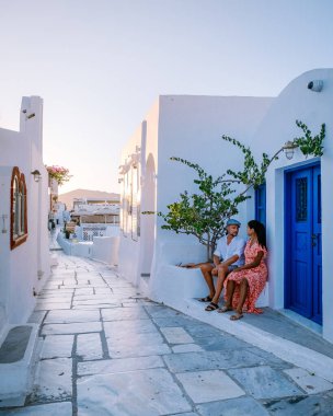 Santorini Yunanistan, genç çift güneş doğarken mavi kubbe kilisesi ve beyazlatılmış Oia Santorini köyünün gündoğumunu izlemek için Santorini Adası 'nda lüks bir tatile çıktılar.