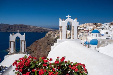 Santorini, Yunanistan. Önünde çiçekler olan küçük caddedeki geleneksel Kiklad Santorini evlerinin resimli görüntüsü. Konum: Oia Köyü, Santorini, Yunanistan. Tatil arkaplanı.