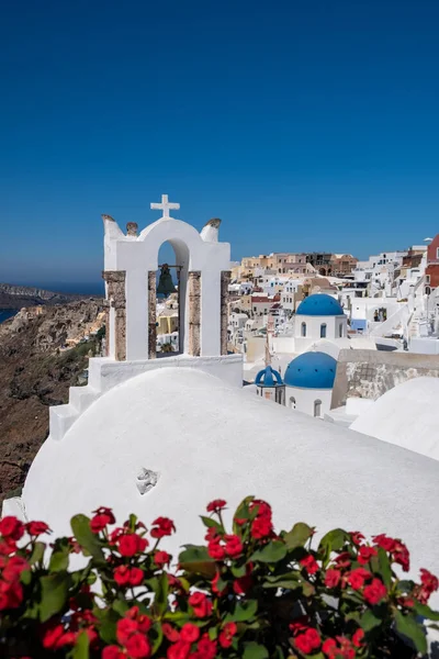Santorini, Greece. Picturesq view of traditional cycladic Santorini houses on small street with flowers in foreground. Location: Oia village, Santorini, Greece. Vacations background. — Stock Photo, Image