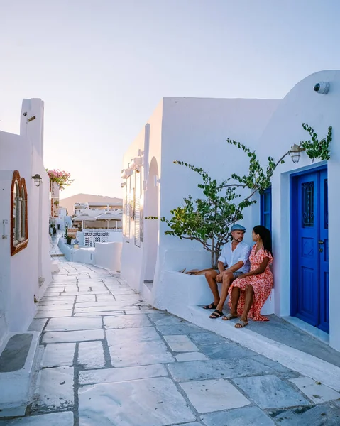 Santorini Grecia, giovane coppia in vacanza di lusso all'isola di Santorini guardando l'alba dalla chiesa cupola blu e villaggio imbiancato di Oia Santorini Grecia durante l'alba, uomini e donne su — Foto Stock