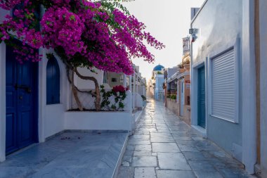 Yunanistan 'ın Santorini Adası' nda gün batımı, güzel, bembeyaz bir köy olan Oia 'da gün batımında kilise ve yel değirmeni.