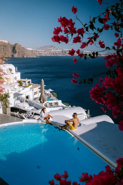 Santorini Griekenland, jong stel op luxe vakantie op het eiland Santorini kijken naar zonsopgang door de blauwe koepel kerk en witgekalkte dorp Oia Santorini Griekenland tijdens zonsopgang, mannen en vrouwen op — Stockfoto