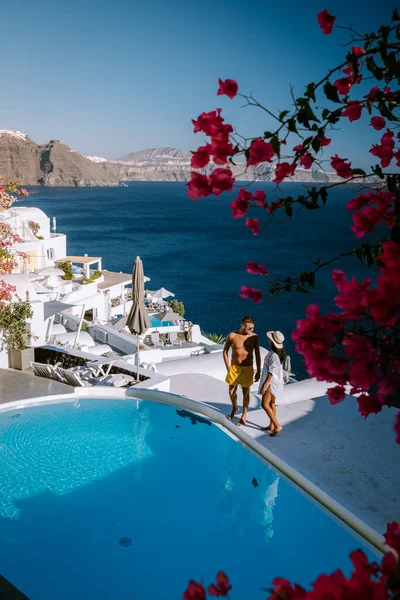 Santorini Griekenland, jong stel op luxe vakantie op het eiland Santorini kijken naar zonsopgang door de blauwe koepel kerk en witgekalkte dorp Oia Santorini Griekenland tijdens zonsopgang, mannen en vrouwen op — Stockfoto
