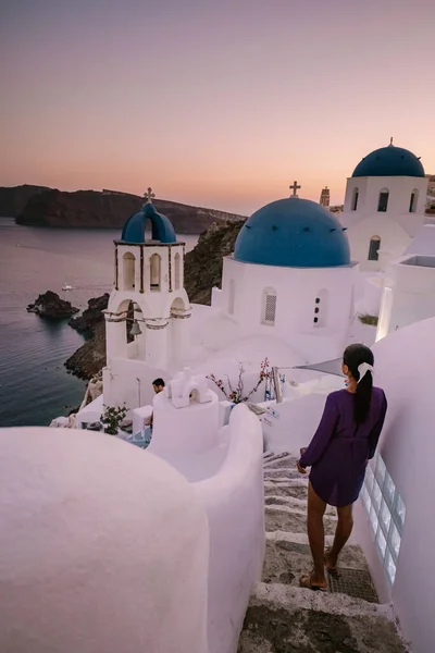 Zachód słońca na wyspie Santorini Grecja, piękna bielona wioska Oia z kościołem i wiatrakiem podczas zachodu słońca Kobieta na luksusowych wakacjach Grecja — Zdjęcie stockowe