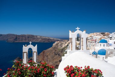 Santorini, Yunanistan. Önünde çiçekler olan küçük caddedeki geleneksel Kiklad Santorini evlerinin resimli görüntüsü. Konum: Oia Köyü, Santorini, Yunanistan. Tatil arkaplanı.