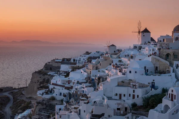 サントリーニ島の夕日ギリシャ,日没の間に教会や風車と美しい白塗りの村Oia — ストック写真