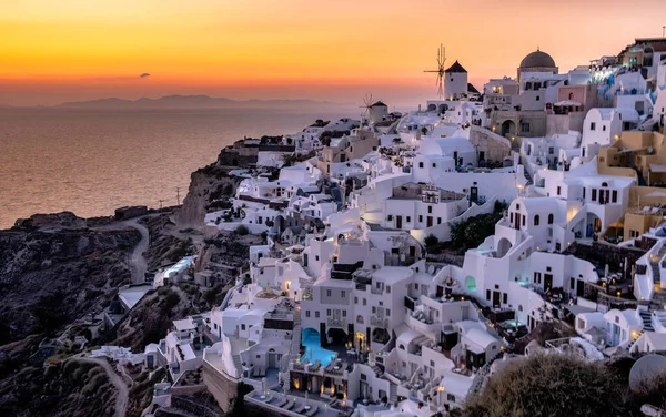 Tramonto all'Isola di Santorini Grecia, bellissimo villaggio imbiancato di bianco Oia con chiesa e mulino a vento durante il tramonto — Foto Stock
