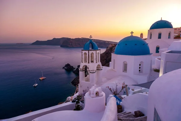 Solnedgång på ön Santorini Grekland, vackra vitkalkade byn Oia med kyrka och väderkvarn under solnedgången — Stockfoto