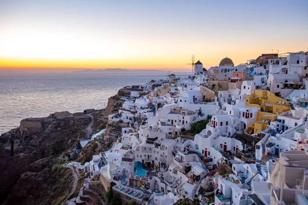 Tramonto all'Isola di Santorini Grecia, bellissimo villaggio imbiancato di bianco Oia con chiesa e mulino a vento durante il tramonto — Foto Stock