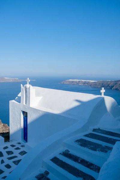 Iglesia blanca en Fira Santorini, Vista panorámica de las montañas, el mar y la naturaleza desde la ciudad de Fira, isla de Santorini Grecia. Vista de la caldera y barcos en la bahía — Foto de Stock