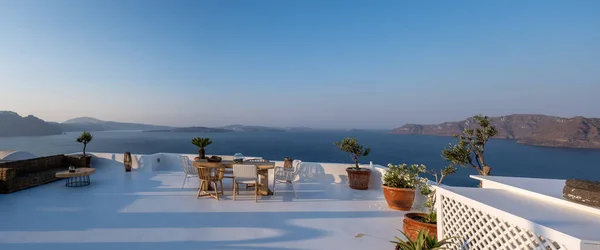 Pôr do sol na ilha de Santorini Grécia, bela aldeia caiada de branco Oia com igreja e moinho de vento durante o pôr do sol — Fotografia de Stock