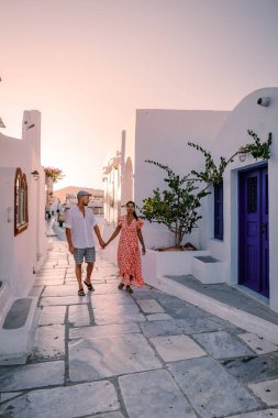 Santorini Yunanistan, genç çift güneş doğarken mavi kubbe kilisesi ve beyazlatılmış Oia Santorini köyünün gündoğumunu izlemek için Santorini Adası 'nda lüks bir tatile çıktılar.