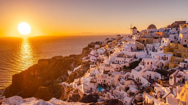 Coucher de soleil sur l'île de Santorin Grèce, beau village blanchi à la chaux Oia avec église et moulin à vent pendant le coucher du soleil — Photo