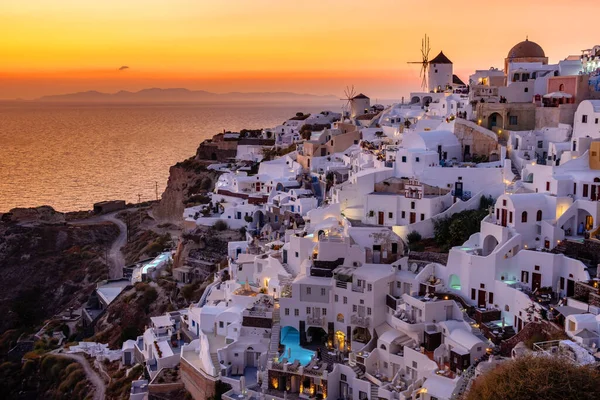 Sonnenuntergang auf der Insel Santorin Griechenland, schönes weiß getünchtes Dorf Oia mit Kirche und Windmühle bei Sonnenuntergang — Stockfoto