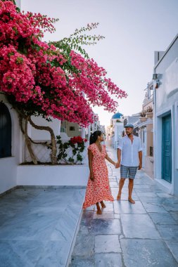 Santorini Yunanistan, genç çift güneş doğarken mavi kubbe kilisesi ve beyazlatılmış Oia Santorini köyünün gündoğumunu izlemek için Santorini Adası 'nda lüks bir tatile çıktılar.