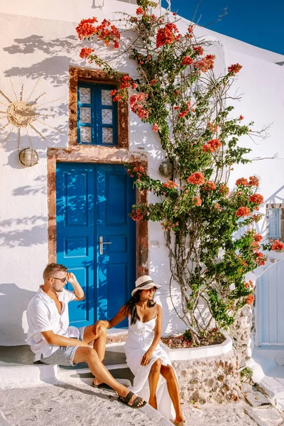 Santorini Grecia, giovane coppia in vacanza di lusso all'isola di Santorini guardando l'alba dalla chiesa cupola blu e villaggio imbiancato di Oia Santorini Grecia durante l'alba, uomini e donne su — Foto Stock