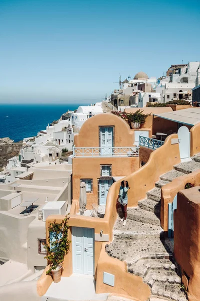 Santorini Griechenland, junger Mann im Luxusurlaub auf der Insel Santorini, der den Sonnenaufgang an der blauen Kuppelkirche und dem weiß getünchten Dorf Oia Santorini Griechenland bei Sonnenaufgang beobachtet, Männer und Frauen auf — Stockfoto