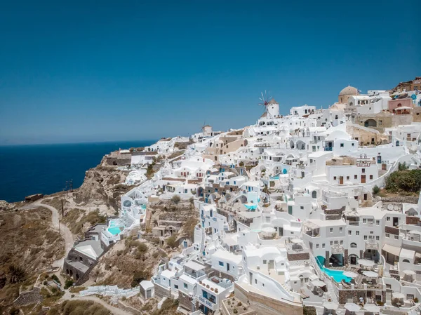 Drone view over Santorini, aerial view over the whitewashed village of Oia with luxury vacation resort with infinity pools in Santorini Greece — Stock Photo, Image