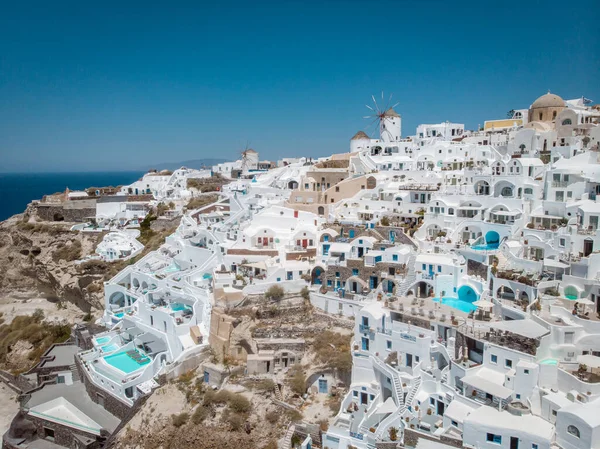 Drone utsikt över Santorini, antenn utsikt över den vitkalkade byn Oia med lyx semesterort med oändliga pooler i Santorini Grekland — Stockfoto