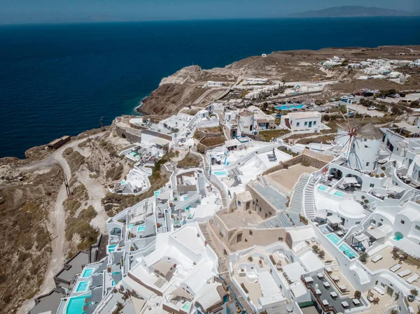 Drone widok na Santorini, widok z lotu ptaka na białą wioskę Oia z luksusowym ośrodku wypoczynkowym z basenami infinity w Santorini Grecja — Zdjęcie stockowe