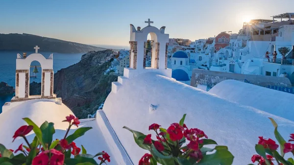 Yunanistan 'ın Santorini Adası' nda gün batımı, güzel, bembeyaz bir köy olan Oia 'da gün batımında kilise ve yel değirmeni. — Stok fotoğraf