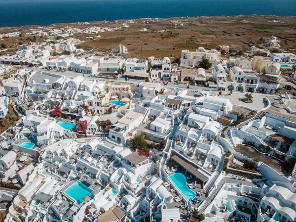 Drone vista sobre Santorini, vista aérea sobre a aldeia caiada de branco de Oia com resort de férias de luxo com piscinas infinitas em Santorini Grécia — Fotografia de Stock