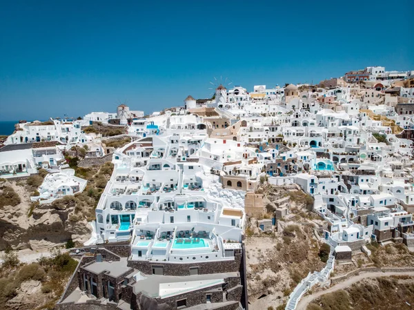 Drone view over Santorini, aerial view over the whitewashed village of Oia with luxury vacation resort with infinity pools in Santorini Greece — Stock Photo, Image