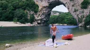 Ardeche France Pont d Arc, Ardeche France sahilindeki çift, Fransa 'nın Ardeche kanyonundaki Vallon Pont Darc' taki Narural kemerini görüyor.