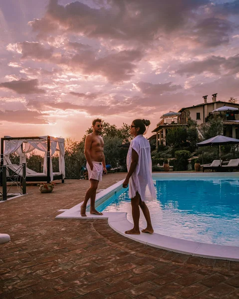 Casa di campagna di lusso con piscina in Italia, Coppia in Vacanza in villa di lusso in Italia, uomini e donne che guardano il tramonto — Foto Stock