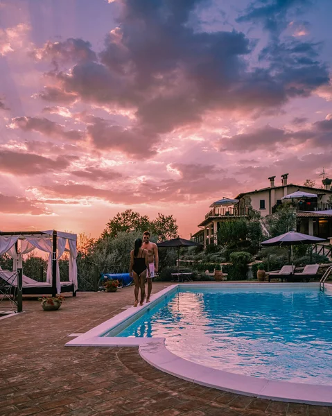 Шикарный загородный дом с бассейном в Италии, Пара в отпуске на роскошной вилле в Италии, мужчины и женщины наблюдают за закатом — стоковое фото