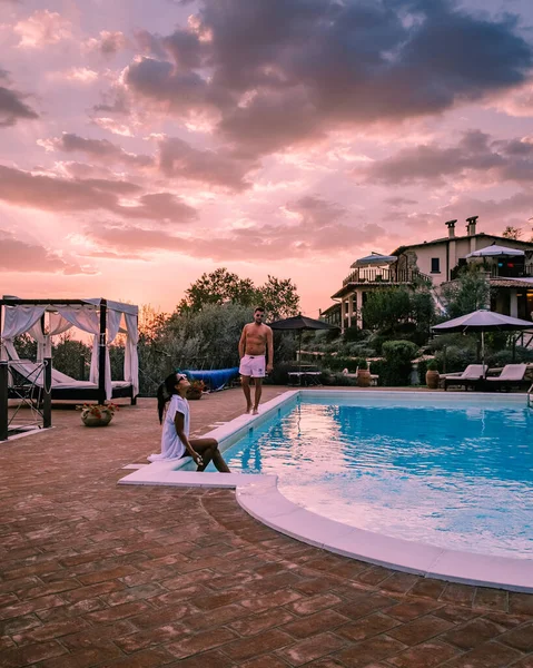 Luxury country house with swimming pool in Italy, Couple on Vacation at luxury villa in Italy, men and woman watching sunset — Stock Photo, Image