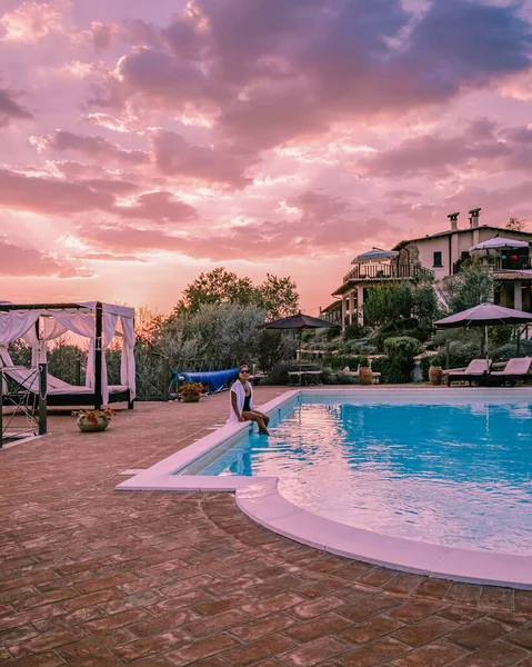 Casa di campagna di lusso con piscina in Italia, Coppia in Vacanza in villa di lusso in Italia, uomini e donne che guardano il tramonto — Foto Stock