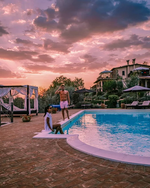 Casa de campo de lujo con piscina en Italia, Pareja de vacaciones en villa de lujo en Italia, hombres y mujeres viendo la puesta de sol —  Fotos de Stock