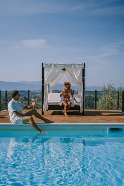 İtalya 'da yüzme havuzlu lüks kır evi, İtalya' da tatil yapan çift, gün batımını izleyen erkek ve kadın.
