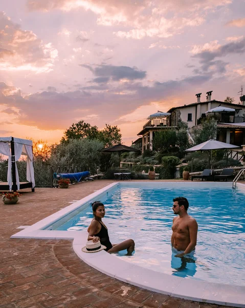 Casa de campo de luxo com piscina na Itália, Casal de férias em Villa de luxo na Itália, homens e mulheres assistindo pôr do sol — Fotografia de Stock