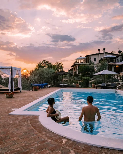 Casa de campo de luxo com piscina na Itália, Casal de férias em Villa de luxo na Itália, homens e mulheres assistindo pôr do sol — Fotografia de Stock