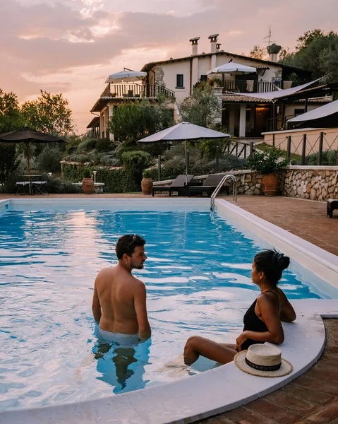 Luxe landhuis met zwembad in Italië, Paar op vakantie in een luxe villa in Italië, mannen en vrouwen kijken naar zonsondergang — Stockfoto