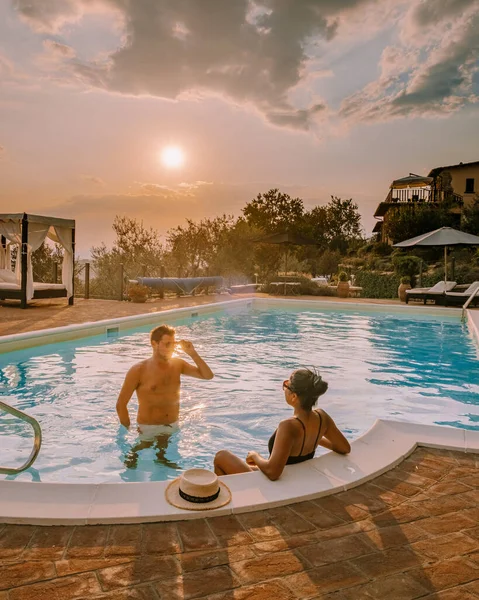Casa di campagna di lusso con piscina in Italia, Coppia in Vacanza in villa di lusso in Italia, uomini e donne che guardano il tramonto — Foto Stock