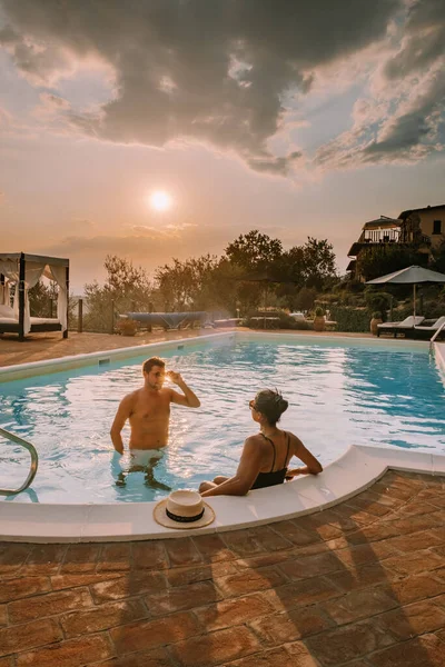 Шикарный загородный дом с бассейном в Италии, Пара в отпуске на роскошной вилле в Италии, мужчины и женщины наблюдают за закатом — стоковое фото