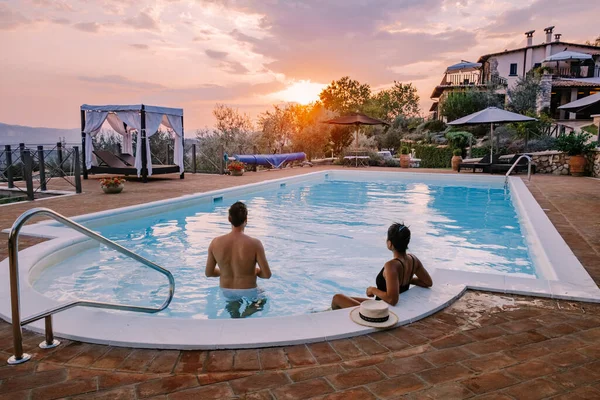 Casa di campagna di lusso con piscina in Italia, Coppia in Vacanza in villa di lusso in Italia, uomini e donne che guardano il tramonto — Foto Stock