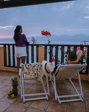 Yunanistan 'da gün doğumunda Meditaryen Denizi' nde kahvaltı masası ve sandalyeler