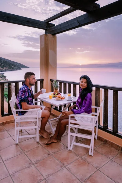 Mesa y sillas con desayuno durante el amanecer en el mar meditario en Grecia — Foto de Stock