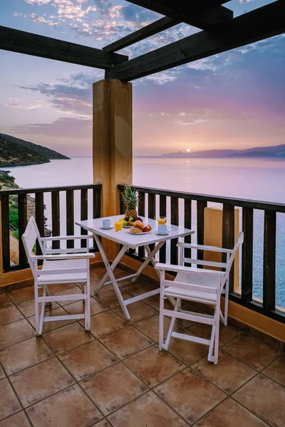 Стол и стулья с завтраком во время восхода солнца на Средиземном море в Греции — стоковое фото